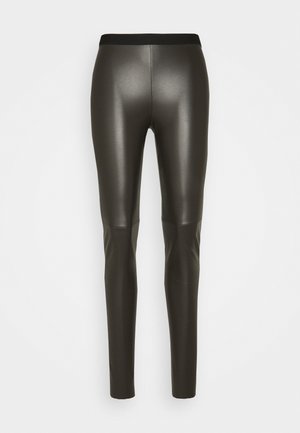 Pantalones ajustados de poli piel negra con cintura elástica, mostrados desde atrás sobre un fondo blanco liso.