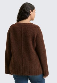 Brązowy sweter dziany o fakturowanym wykończeniu, z szerokim dekoltem, długimi rękawami i prążkowanym dołem. Z tyłu ozdobiony centralnym szwem.