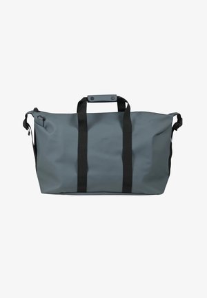 Bolsa de viaje impermeable gris con correas negras, cierre de asa con botón a presión y clips ajustables en las correas laterales.