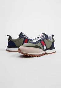 Sneakers con tomaia in tessuto verde, accenti blu navy, strisce rosse e bianche, punta in suede, lacci bianchi e suola in gomma testurizzata.