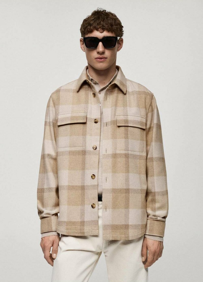 Cămașă din flanel cu model tartan bej, cu două buzunare pe piept, închidere cu nasturi și manșete. Are o textură moale, croială lejeră și tonuri de culoare calde.