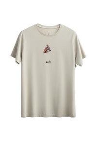 Crème-kleurig t-shirt van zacht katoen, met een centrale grafische afbeelding van een personage met een bruine cape en blauwe accenten.