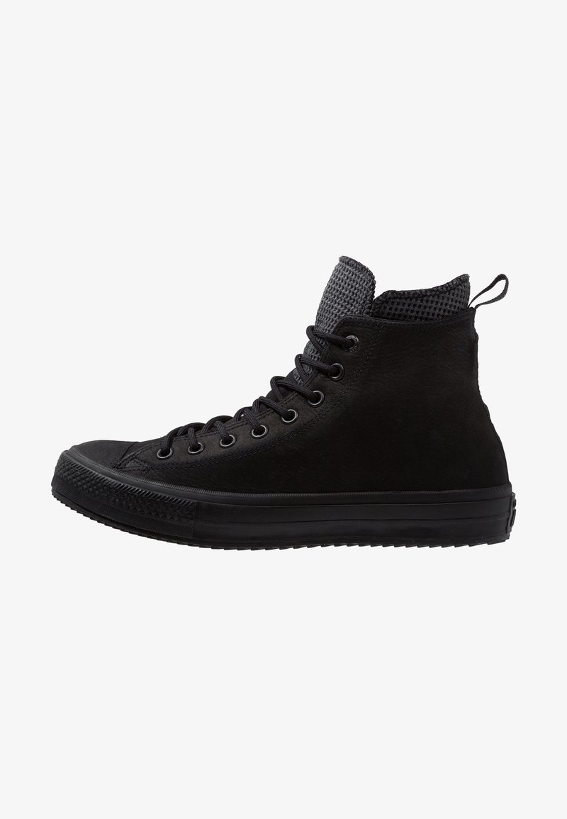 Basket montante noire avec languette texturée, lacets noirs, semelle en caoutchouc et languette à l'arrière, vue de l'extérieur.