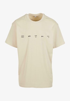 Cremefarbenes T-Shirt mit schwarzem Text: "ALWAYS COMMIT", "RAISE ALL" und "BOLD IN", mit Spielkarten-Symbolen zwischen den Phrasen. Mit kurzen Ärmeln.