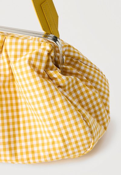 Sac en tissu vichy jaune et blanc avec un cadre métallique et une bandoulière en cuir jaune sur un fond blanc.