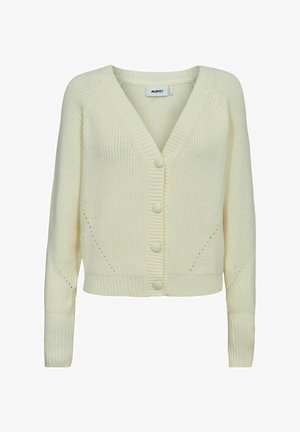 Grietos spalvos megztinis su V formos iškirpte, su šonkaulių tekstūra, penkiais mygtukais priekyje ir šoninėmis kišenėmis. Papuoštas atvirų audinių akcentais.