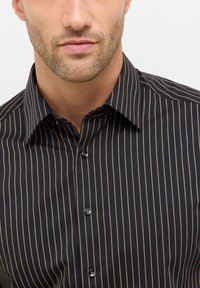 Schwarz gestreifte Dressshirt mit dünnen goldenen vertikalen Streifen, Knopfleiste vorne, spitzem Kragen und glatter Stofftextur.