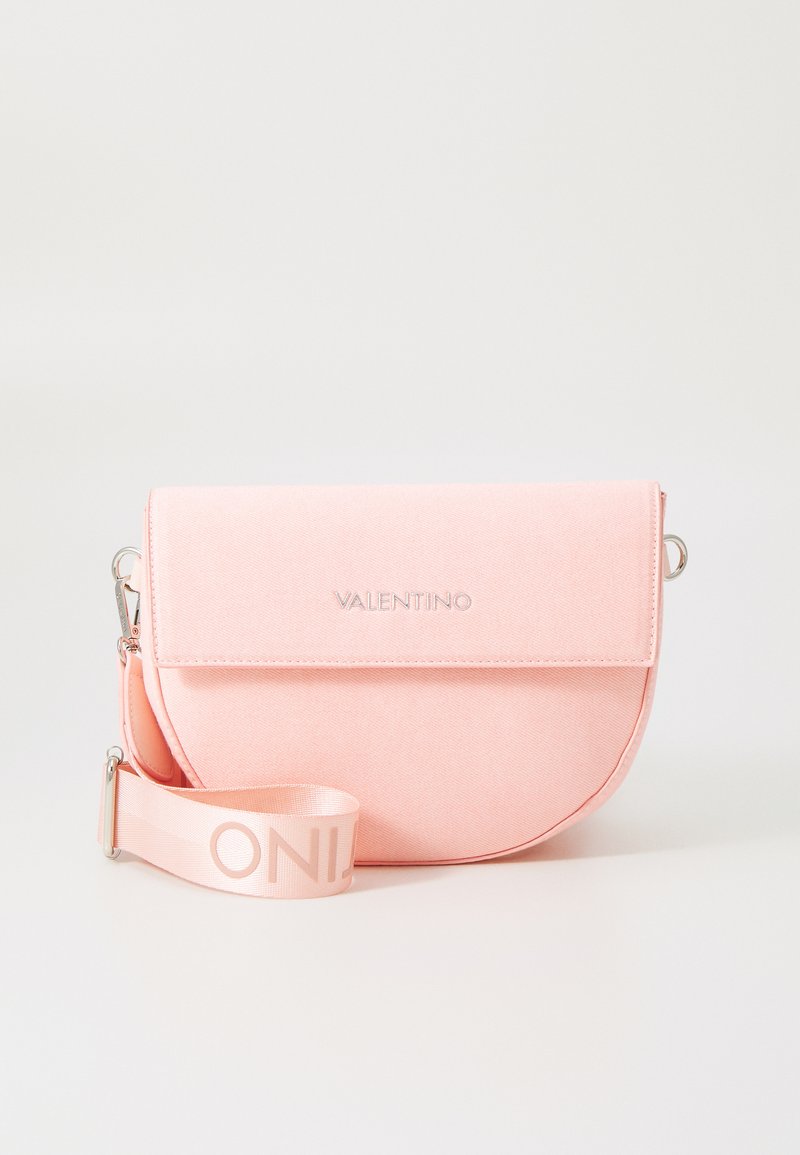 Ružová taška cez telo s oblým tvarom, magnetickým klapkou a embosovaným logom "VALENTINO"; obsahuje mäkký popruh s brandingom.