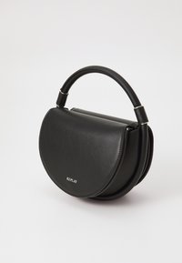 Sac à main en cuir noir avec une forme incurvée, un corps structuré et une poignée supérieure. Présente un logo discret et une texture lisse.