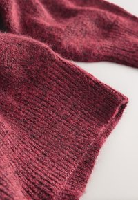 Pulover tricotat în roșu închis, cu o țesătură texturată și un model cu dungi, prezentând fibre moi și pufoase și o croială ușor largă.