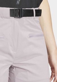 Light purple pants with a textured finish, featuring a black adjustable belt and two zipped front pockets.