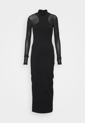 Musta pitkähiuksinen poolomekko, jossa on läpikuultavat hihat ja hartiapaneelit, vartalonmyötäinen siluetti ja nilkkapituinen helma.