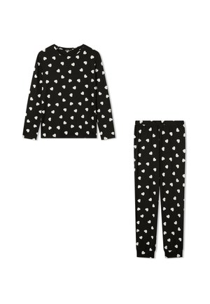 Pigiama in morbido tessuto composto da una maglia nera a maniche lunghe e pantaloni abbinati con motivi di cuori bianchi. La maglia presenta un collo rotondo; i pantaloni hanno una cintura elastica.
