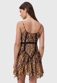 Vestido de estampa de leopardo com acabamento em renda preta, alças ajustáveis e um design fluido com uma bainha assimétrica.