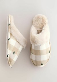 Pair of beige and white checkered slippers with green tree patterns and soft beige faux fur lining on a light background.