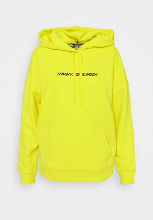 Felpa con cappuccio di colore giallo neon con ampia tasca frontale, maniche lunghe e coulisse regolabile. Presenta il logo "TOMMY HILFIGER" in nero. Tessuto morbido.