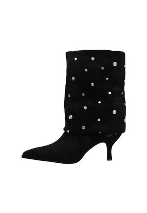 Bota negra de ante hasta media pantorrilla con punta fina, tacón bajo y tachuelas plateadas dispersas en la caña.