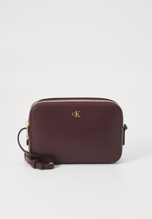 Borsa a tracolla rettangolare in pelle bordeaux scuro con zip dorata e piccolo logo CK dorato sul davanti, dotata di tracolla regolabile.