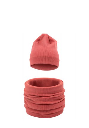 Korálowy zestaw zimowy z prążkowanego dzianiny z czapką i pasującym ocieplaczem na szyję, pokazany na białym tle.