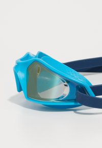 Lunettes de natation bleues avec une monture en silicone lisse, des lentilles anti-buée et une sangle sombre. Présente un design contourné pour un ajustement parfait.