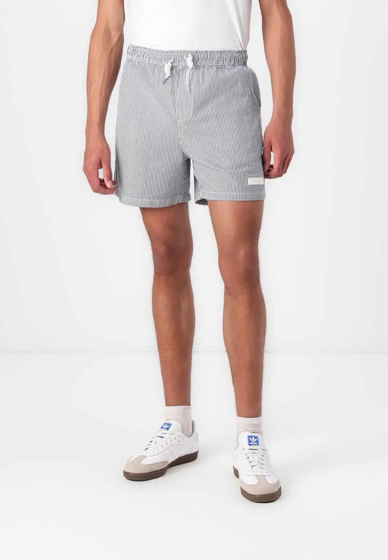 Stribede badeshorts i blå og hvid med elastisk talje, snor, sidelommer og en lille logo-patch på benet.