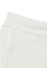 Geripptes weißes Strickgewebe mit einem weichen, elastischen Bund und einer glatten Textur, geeignet für legere oder bequeme Kleidung.