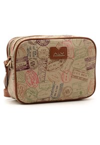 Beżowa torba skórzana z kolorowymi nadrukami pieczątek paszportowych, brązowymi akcentami, z zamkiem błyskawicznym i metką z logo po jednej stronie.