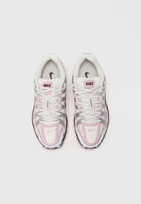 Nike tenisice s gornjim dijelom od mrežice u bijeloj i svijetlo ružičastoj boji, s reflektirajućim srebrnim detaljima, okruglim vrhom i vezanjem.