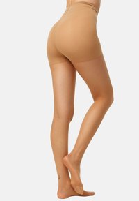 Pantalones cortos moldeadores beige con una textura suave, cintura alta y un diseño sin costuras. La tela es transparente en las piernas, realzando un aspecto natural.