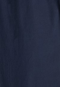 Tessuto blu navy con una superficie liscia e una lieve lucentezza, che presenta una colorazione uniforme senza motivi visibili o dettagli metallici.