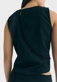 Czarny bezrękawnik z wygiętym szwem i dekoracyjnymi guzikami z tyłu. Wykonany z gładkiej tkaniny o eleganckim designie.