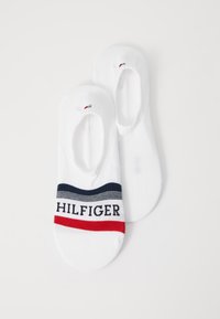 Weiße Knöchelsocken mit einem navy- und rot gestreiften Band, auf dem "HILFIGER" in schwarzer Schrift steht. Glatte Textur mit tiefem Schnitt und minimalen Nähten.