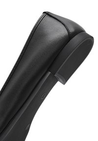 Black leather shoe with a pointed toe, smooth finish, and a textured rubber sole. Features a sleek design and minimalistic detailing.
