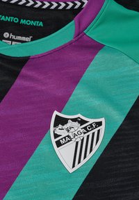 Hummel trøje med sort, teal og lilla striber. Korte ærmer, rund hals og et hvidt skjoldlogo med "MALAGA C.F." på brystet.