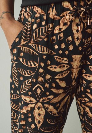 Pantalons noirs avec un motif complexe de feuilles en bronze et géométrique, dotés de poches et d'une taille à cordon avec des accents en métal.