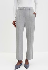 Grijze wijde broek in een gestructureerde stof, met een knoopsluiting, zijzakken en een getailleerde pasvorm, gecombineerd met puntige grijze schoenen.