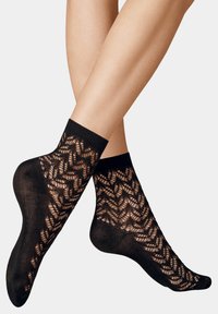 Schwarze Spitzenknöchelsocken mit einem strukturierten Blattmuster, geripptem Bündchen und transparenter Optik, die das filigrane Design und die Handwerkskunst hervorheben.