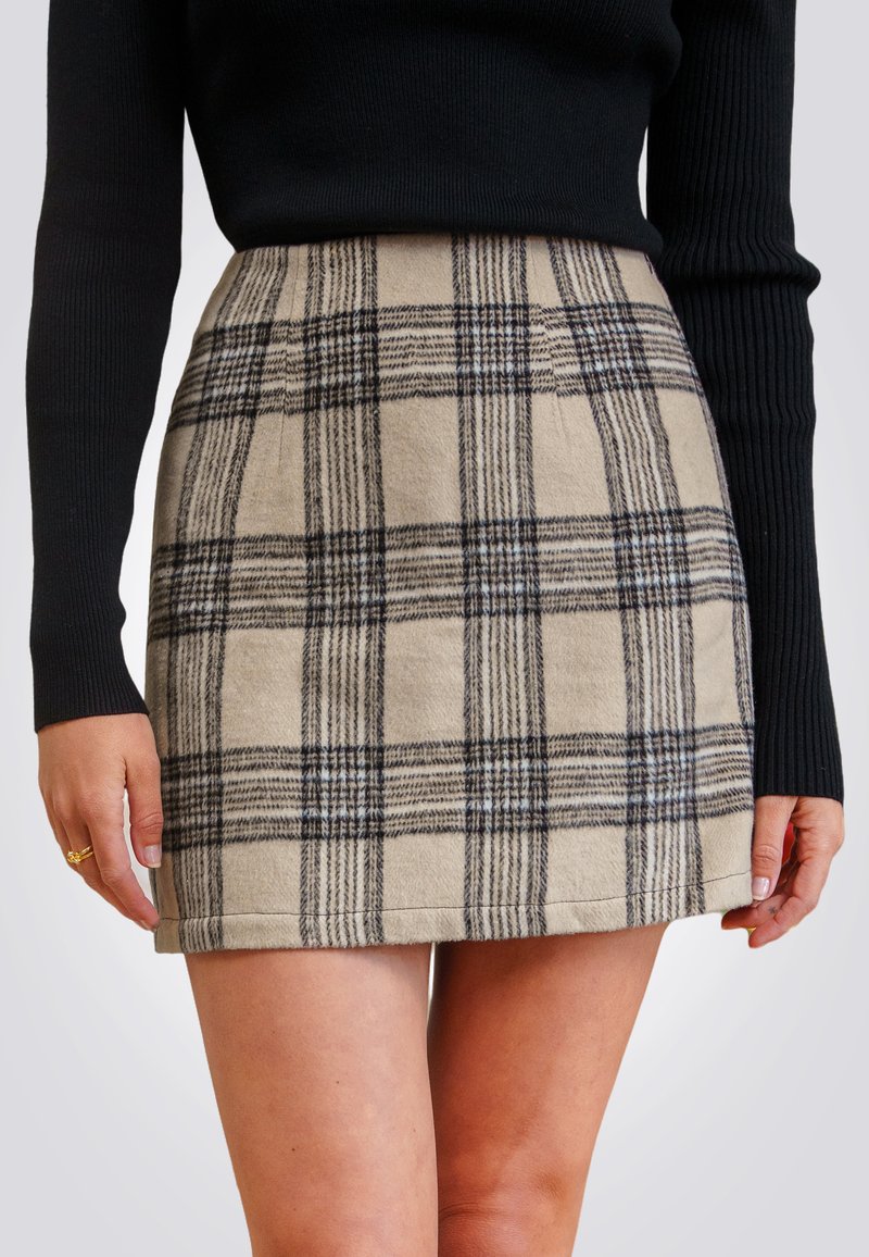 Jupe à carreaux beiges présentant des lignes noires et bleues, fabriquée en tissu texturé, avec une silhouette ajustée et un ourlet qui se situe au-dessus du genou.