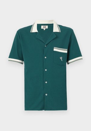 Šī ir īsām piedurknēm teal krāsas krekls ar teksturētu audumu, baltu apkakli un piedurkņu akcentiem, priekšējo kabatu un dekoratīvu sirds izšuvumu.