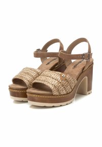 Sandalias de plataforma marrones y beige con parte superior trenzada, correa ajustable en el tobillo y un tacón robusto. Presenta patrones texturizados y acentos en contraste.