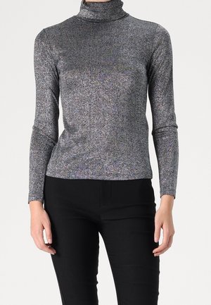Silberner, langärmeliger Rollkragenpullover mit weich glänzender Textur und subtilen Glitzereffekten, kombiniert mit schwarzen, figurbetonten Hosen.