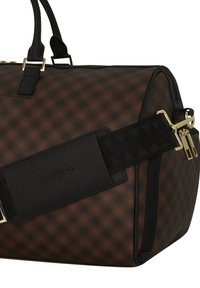 Bolso de viaje de color marrón con estampado, con detalles en negro, que cuenta con herrajes en dorado y una resistente correa para el hombro, hecho de material sintético duradero.