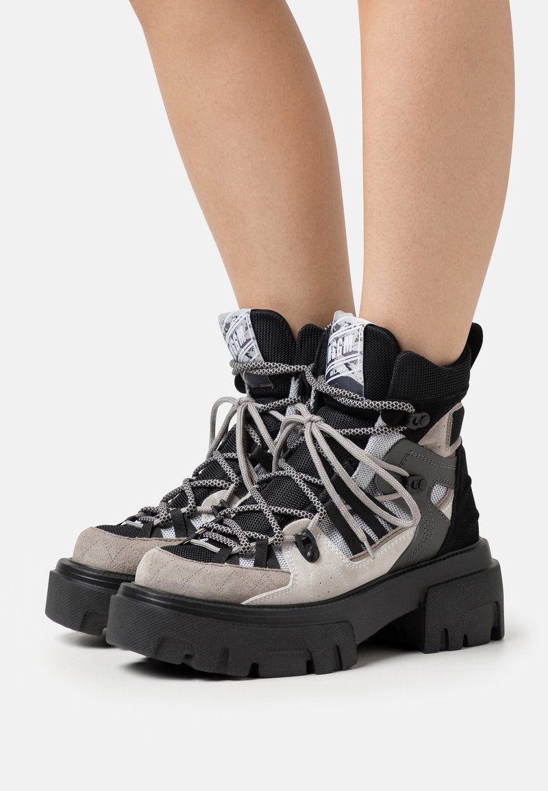 Buty trekkingowe w połączeniu szarego zamszu i czarnej siateczki, z grubymi gumowymi podeszwami, wyraźnymi sznurowadłami i wyściełanym kołnierzem z logo.