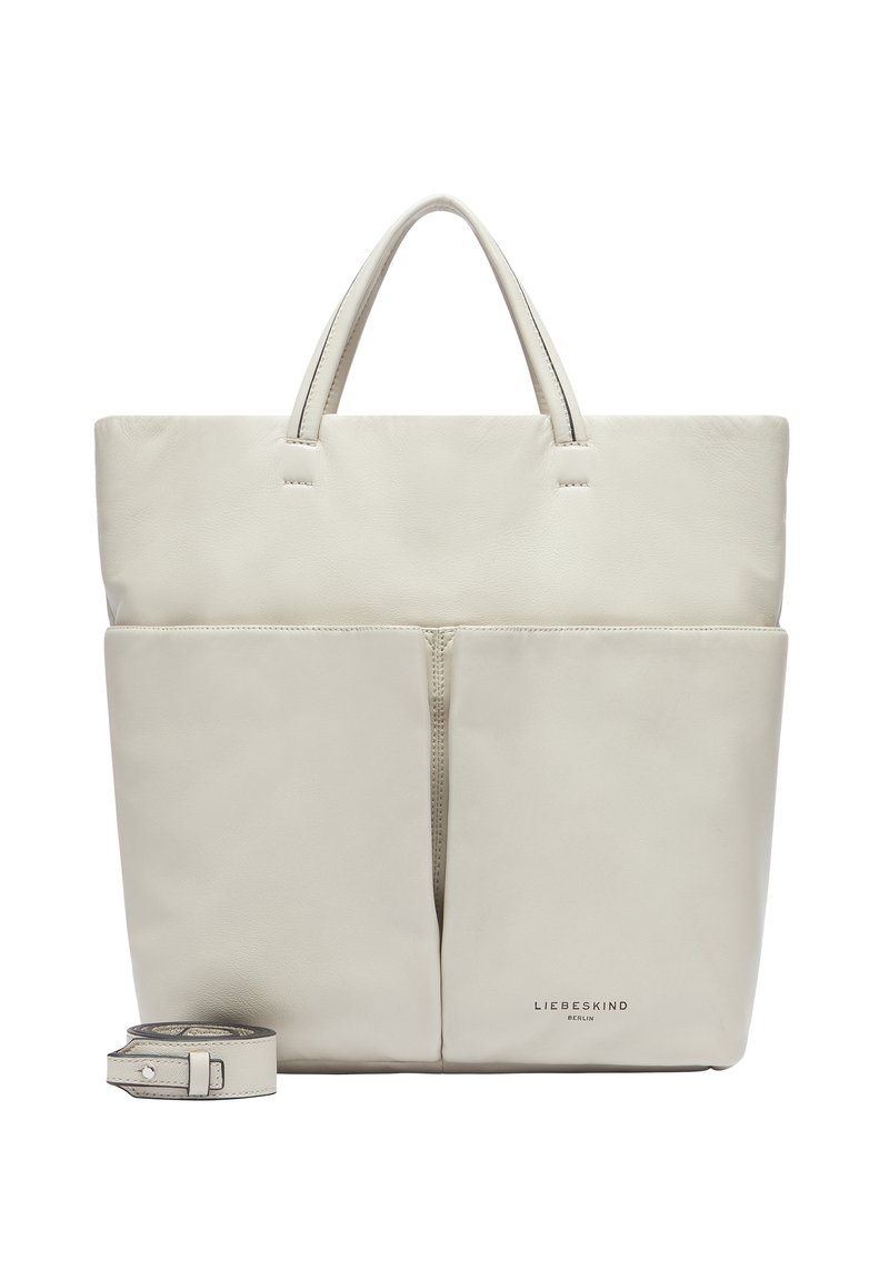 Ledertasche in sanftem Cremefarbton, mit zwei Vorderfächern, kurzen Griffen und einem abnehmbaren Tragegurt. Subtil geprägtes Logo am Boden.