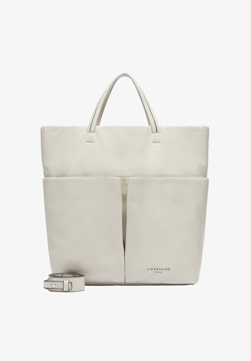 Ledertasche in sanftem Cremefarbton, mit zwei Vorderfächern, kurzen Griffen und einem abnehmbaren Tragegurt. Subtil geprägtes Logo am Boden.