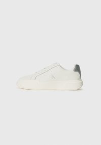 Weißer Sneaker aus Leder mit glatter Textur, ausgestattet mit einem silbernen Akzent an der Ferse, flacher Sohle und minimalistischem Design.