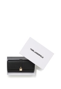 Portofel negru Karl Lagerfeld cu închidere cu lacăt auriu, într-o cutie albă cu capac parțial deschis care arată numele brandului.