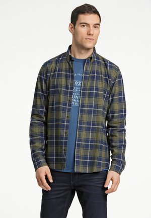 Long-sleeve plaid shirt in green and navy, featuring a button-down collar and a soft texture, layered over a blue t-shirt with printed design.