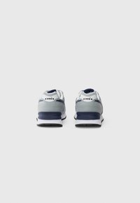 Gray and white sneakers with a textured upper, navy accents, cushioned sole, and a contrasting black rubber outsole.