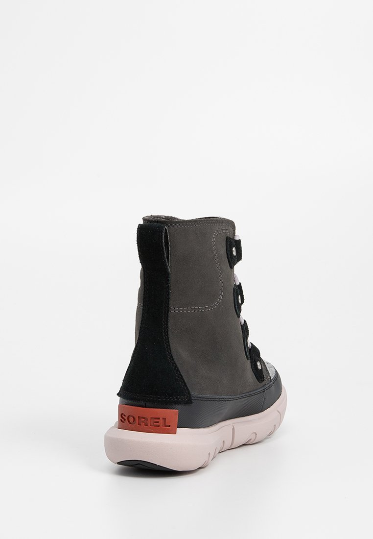 Graue Wildleder-Stiefelette mit schwarzem Absatz und Gummisohle, mit einer Schnürung an der Vorderseite und einem Logopatch an der Rückseite des Absatzes.